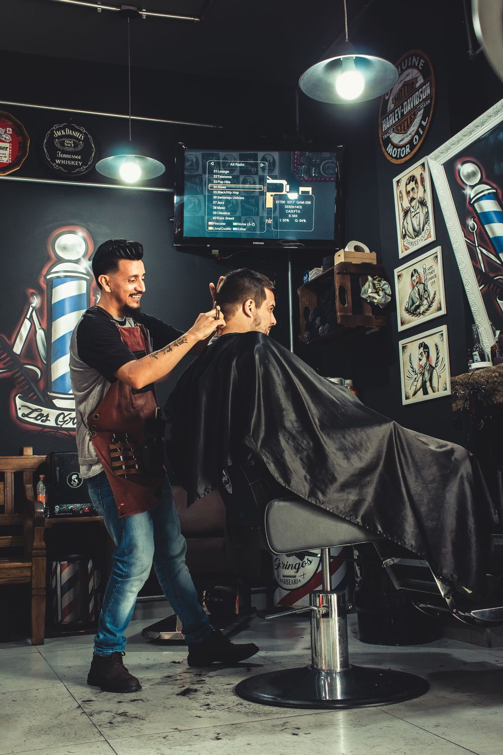 A barber cutting a customer's hair in his shop