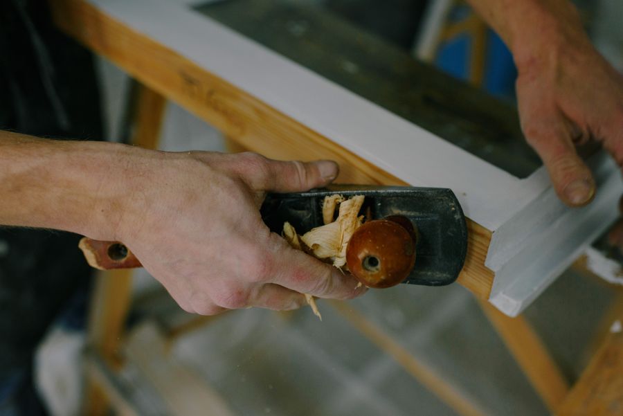 A joiner hand-planing a sash window frame