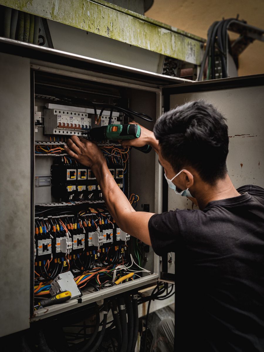 An electrician working on a wiring panel